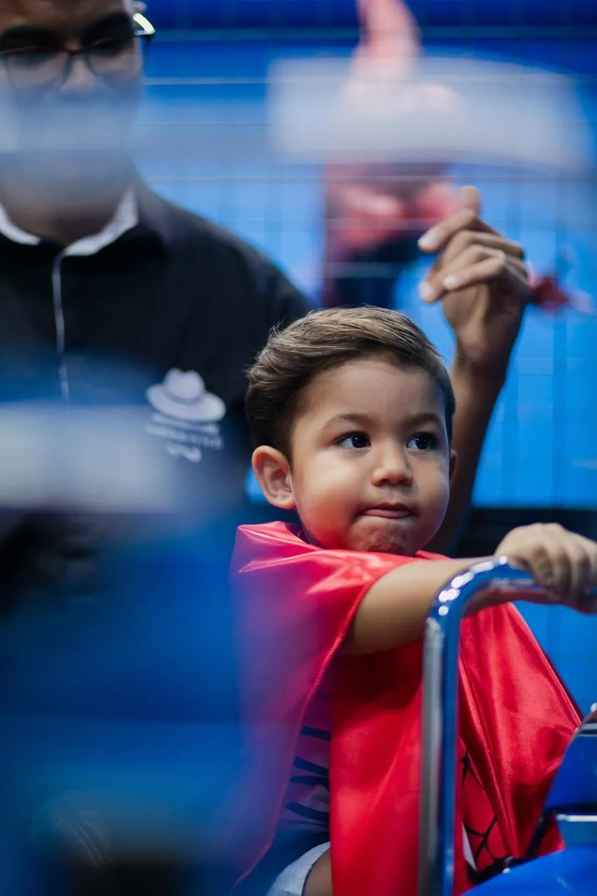 Menino cortando o cabelo no espaço kids